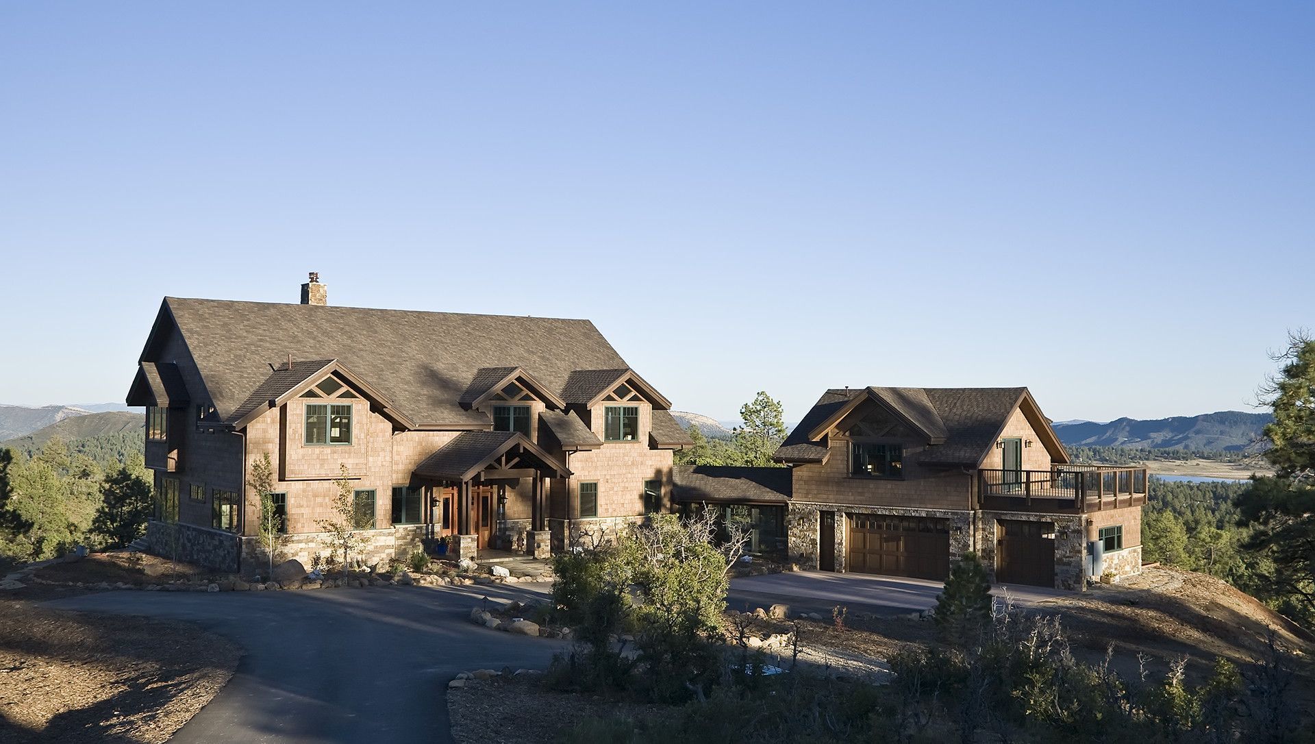 A large house sits on top of a hill next to a road