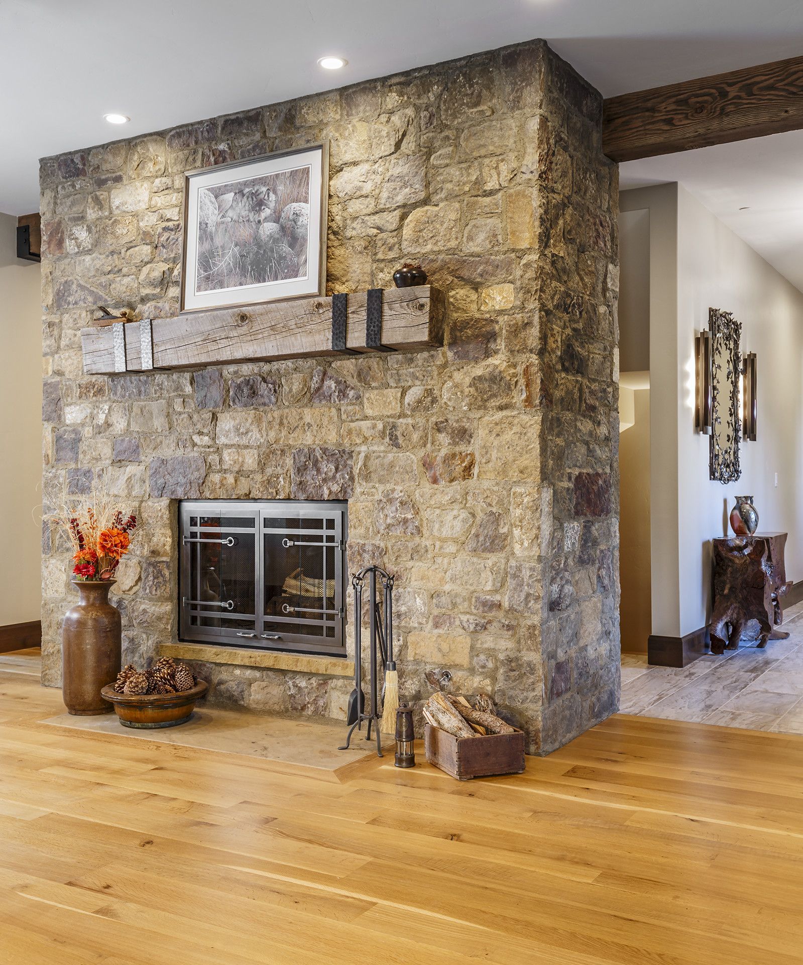 A living room with a stone fireplace and wood floors