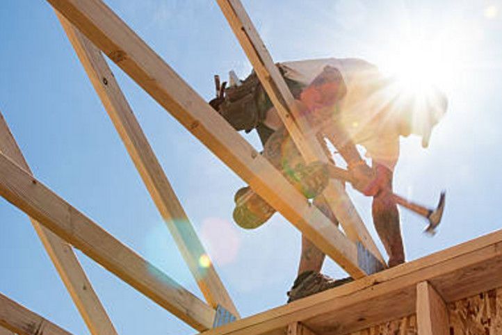 A man is working on a wooden structure with a hammer.