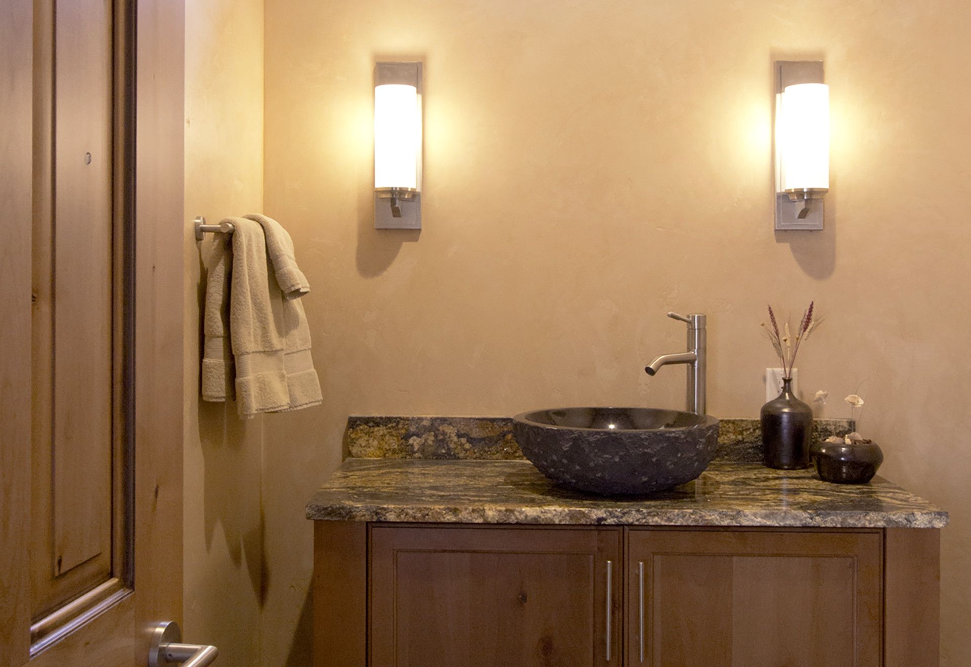 A bathroom with a sink and two lights on the wall