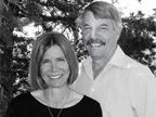 A man and a woman are posing for a picture in a black and white photo.