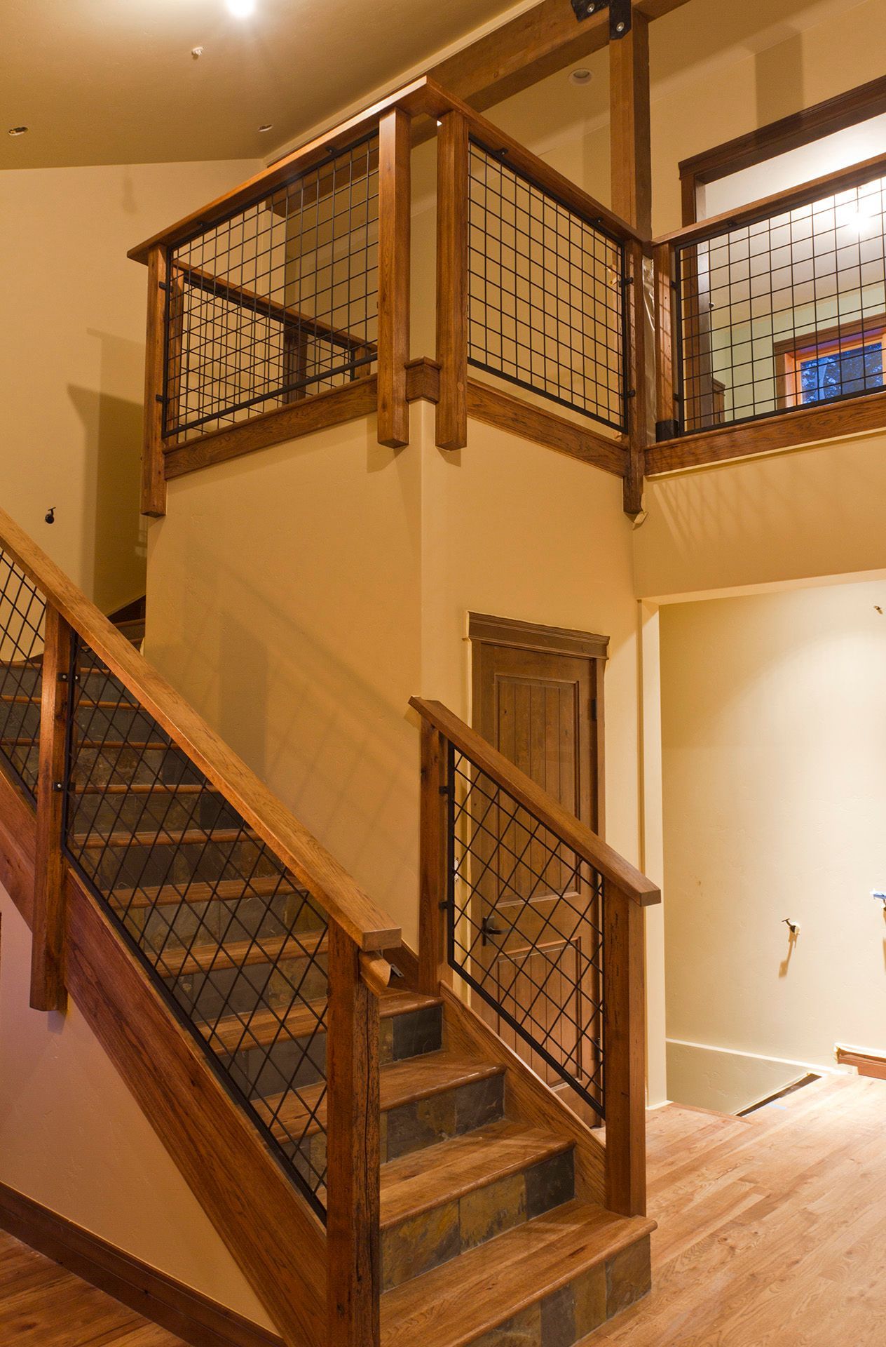 A wooden staircase with a metal railing in a house