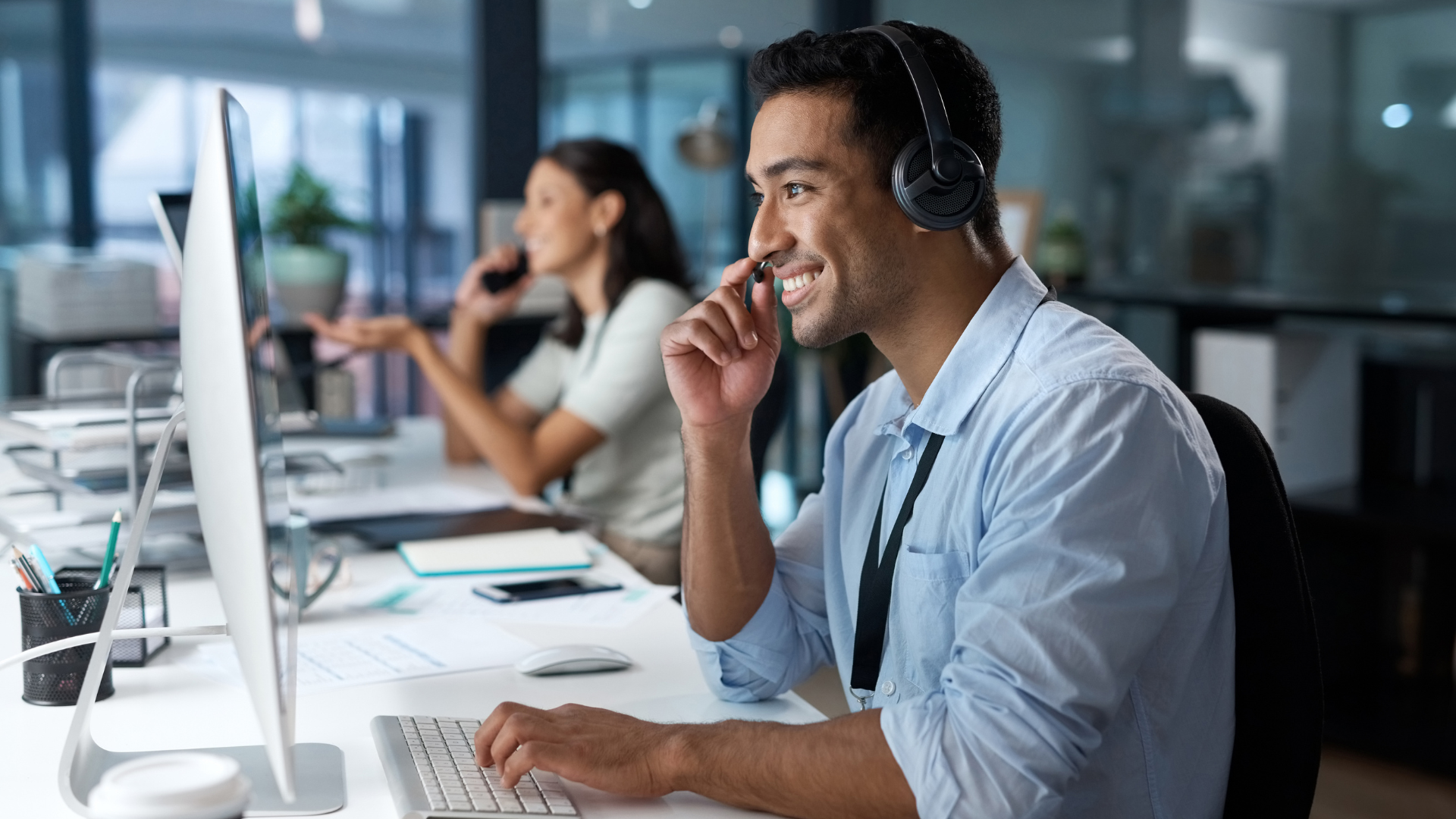 a man wearing headphones is sitting in front of a computer .