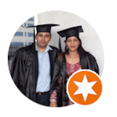 a man and a woman wearing graduation caps and gowns are posing for a picture .