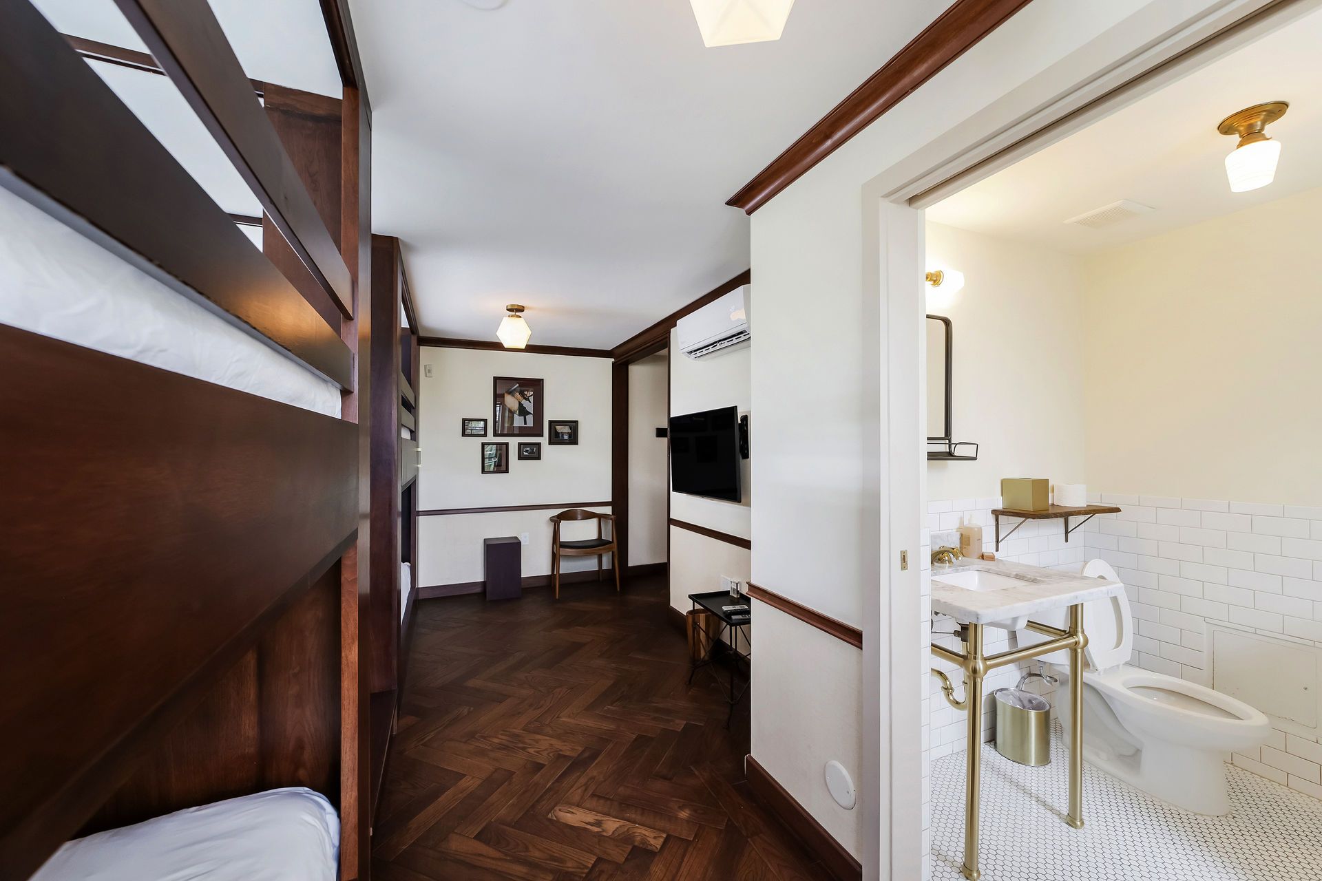 Hallway with dark wood paneling, parquet floor, and bathroom visible on the right.