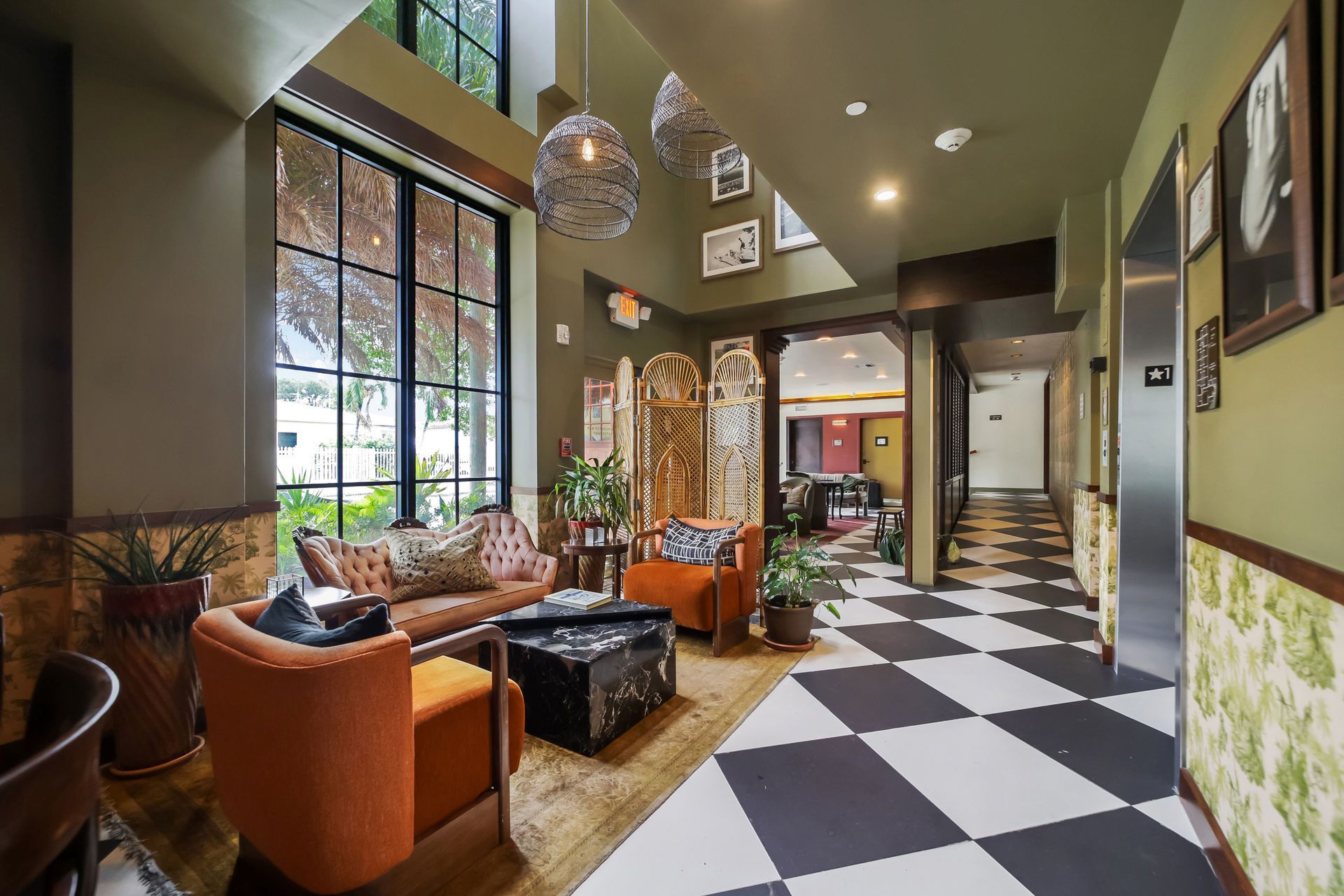 Lobby with seating, black and white checkered floor, and open doorway to hallway.