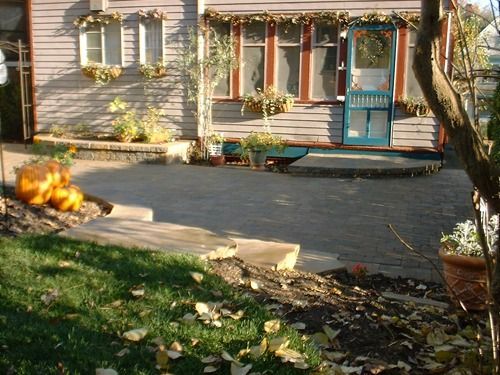 House exterior with blue door, pumpkins, and a stone walkway.