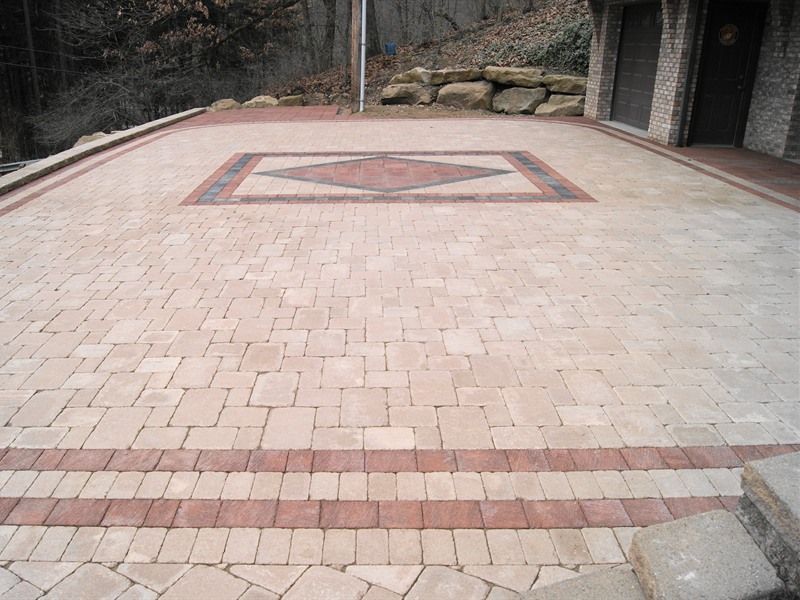 Brick patio with a red diamond-shaped design; a border of red bricks is visible.
