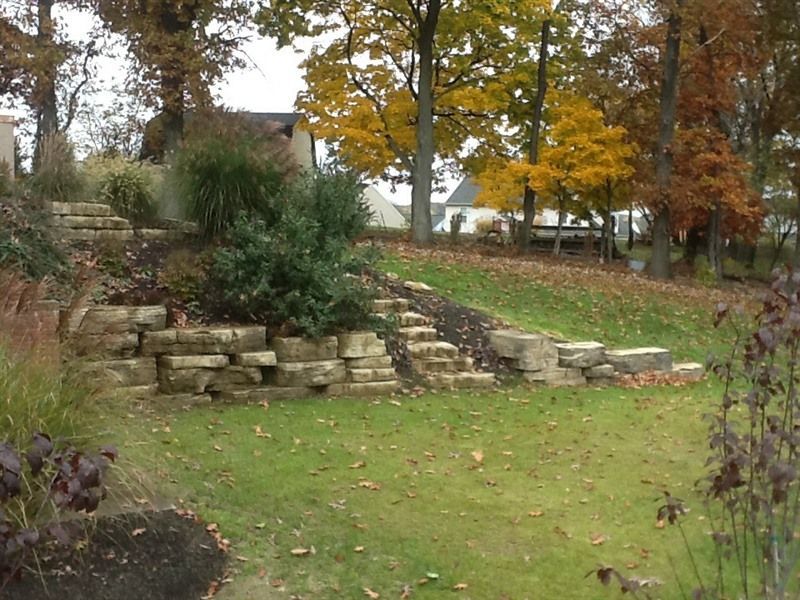 Stone steps on a hillside with fall foliage in background.