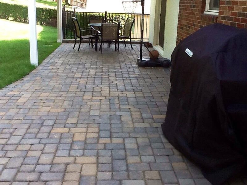 Brick patio with outdoor seating area and covered grill.