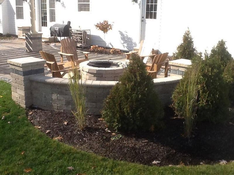 Patio with a fire pit, Adirondack chairs, and landscaping.