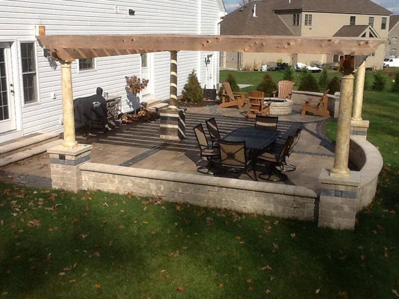 Backyard patio with pergola, seating area, and landscaping.