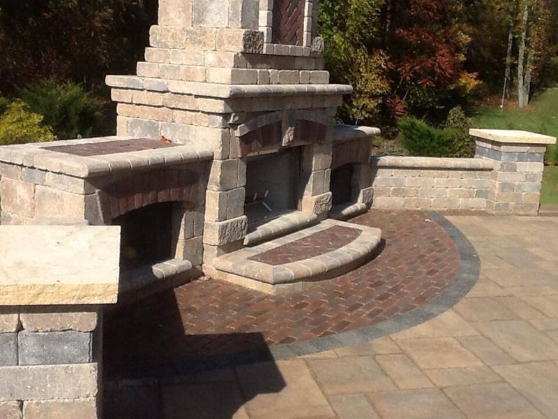 Outdoor brick fireplace with surrounding patio area.