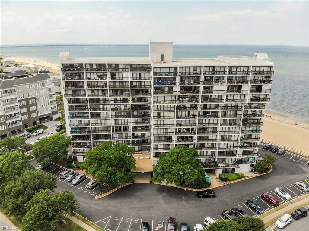 An aerial view of a large building with a parking lot in front of it.