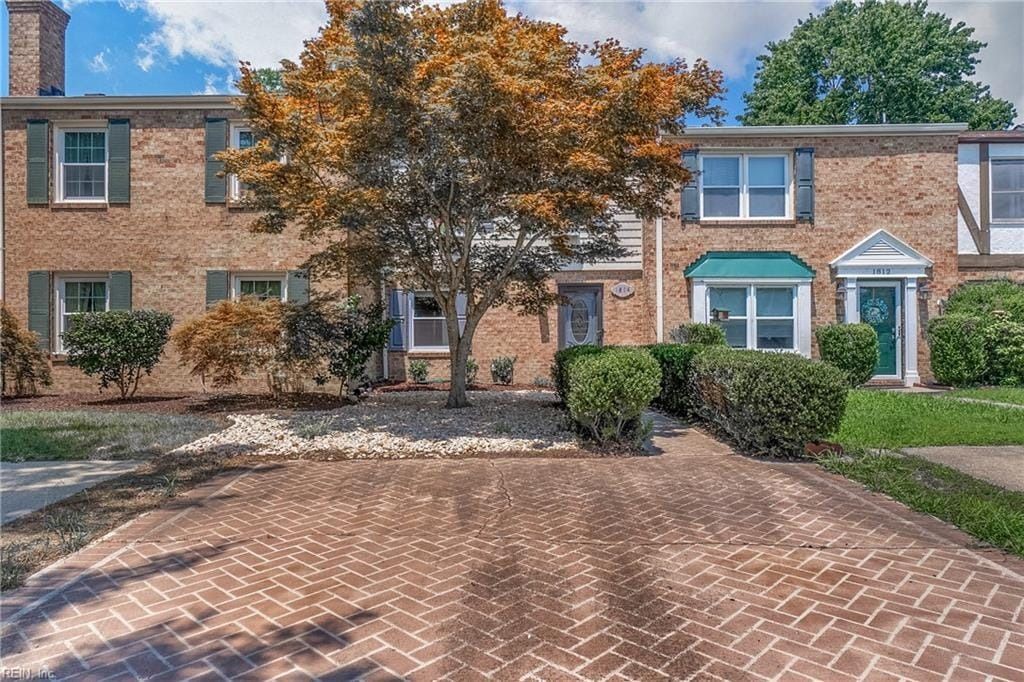 A brick house with a tree in front of it