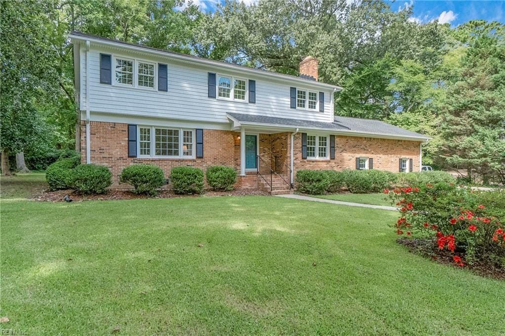 A large brick house with a large lawn in front of it is for sale.