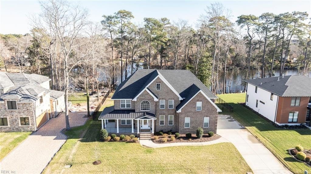 An aerial view of a large brick house surrounded by trees.