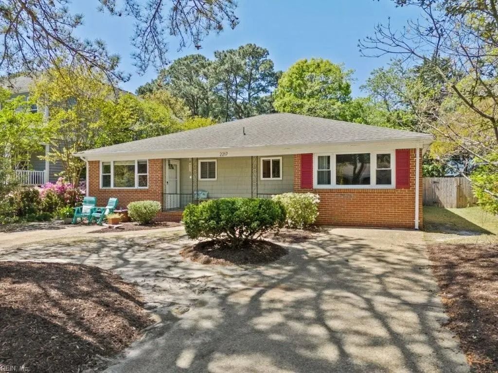 A house with a driveway and trees in front of it