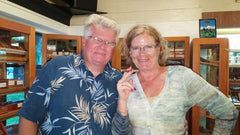 A man and a woman are posing for a picture in a library.