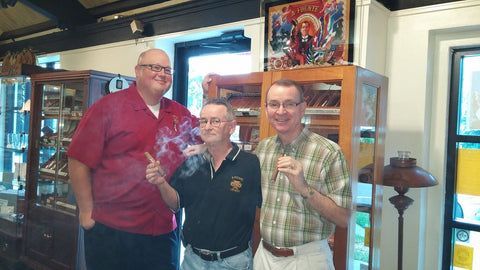 Three men are posing for a picture in a room.