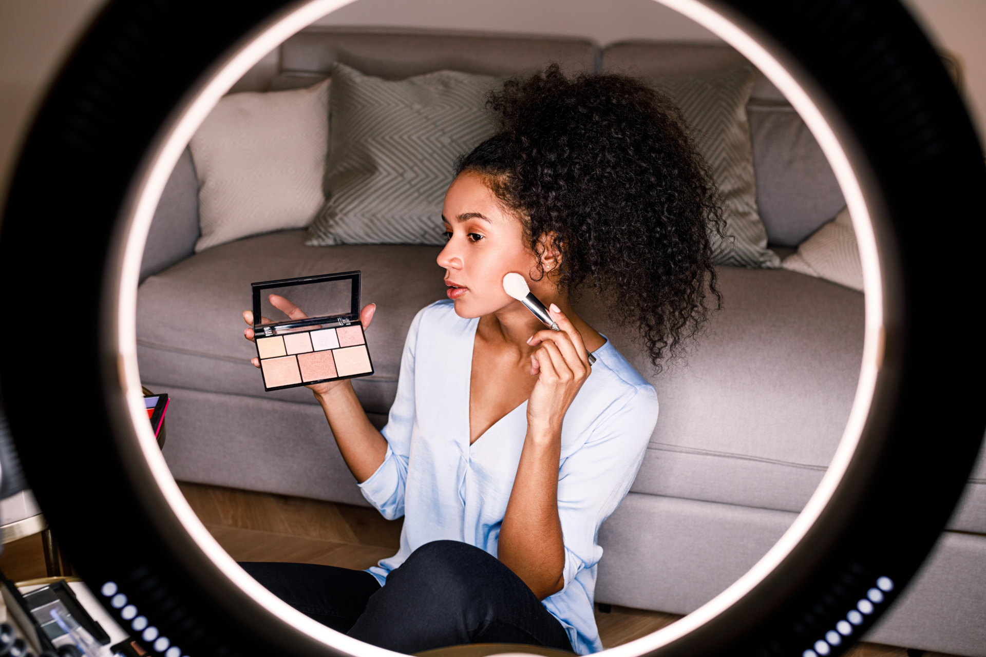 Girl putting on makeup with ring light and video