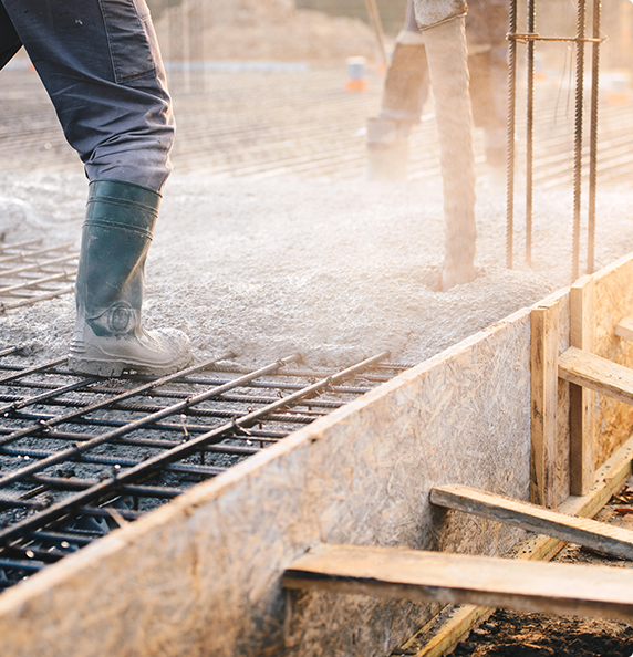 A man is pouring concrete on a construction site.