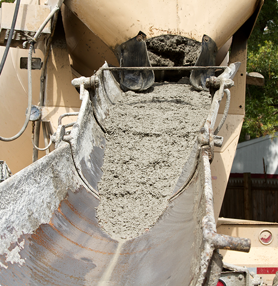 A concrete mixer is pouring concrete into a bucket