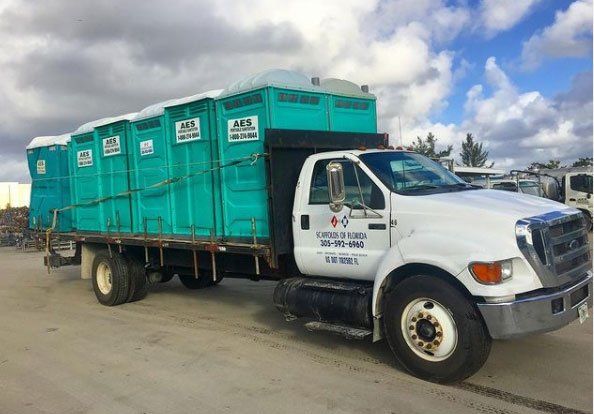 Side View of Teal Portable Toilets in the Truck — Miami, FL — A.E.S. Portable Sanitation, Inc.
