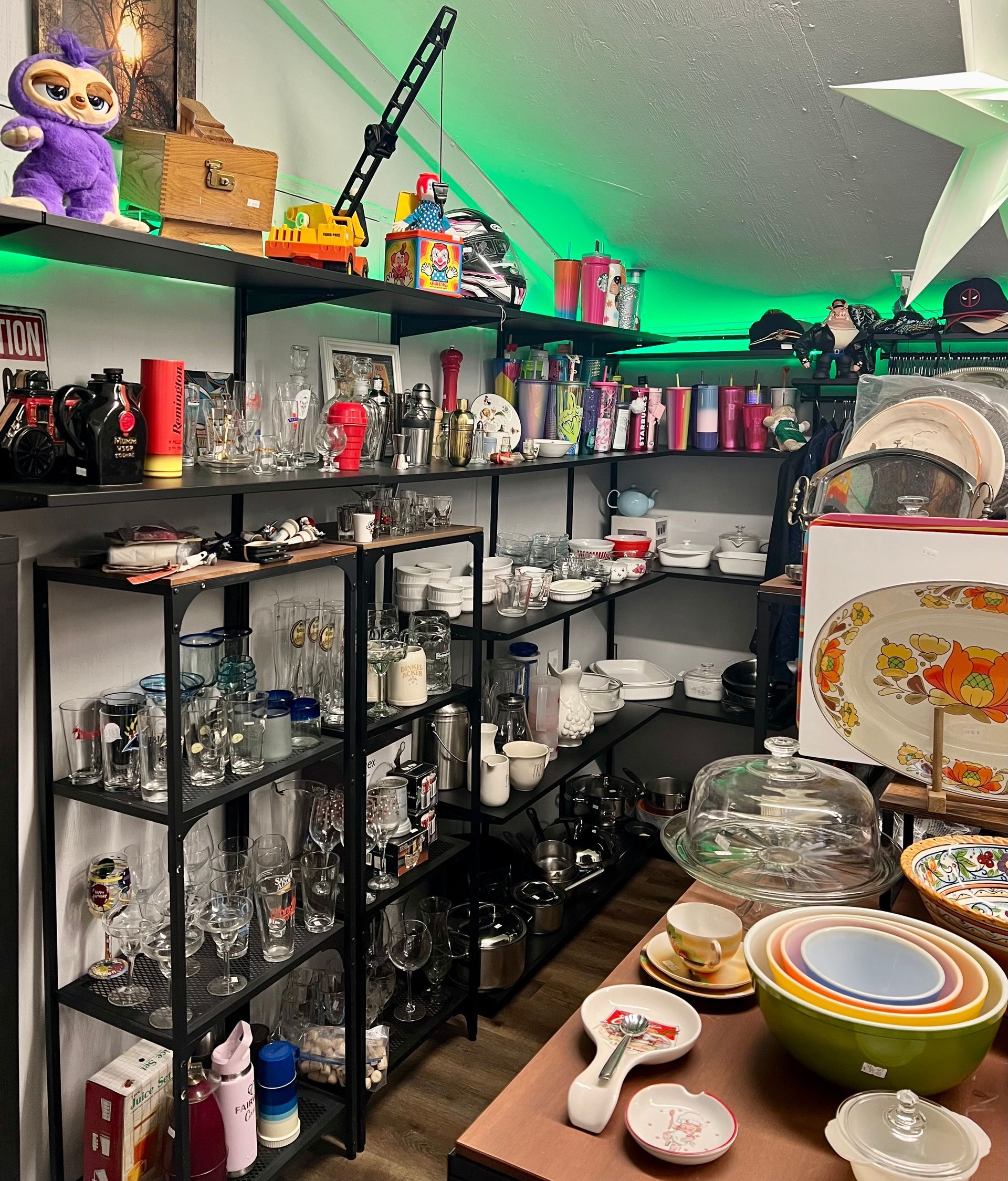 Shelves filled with various glassware, figurines, and kitchenware, with a colorful bowl set in the foreground.