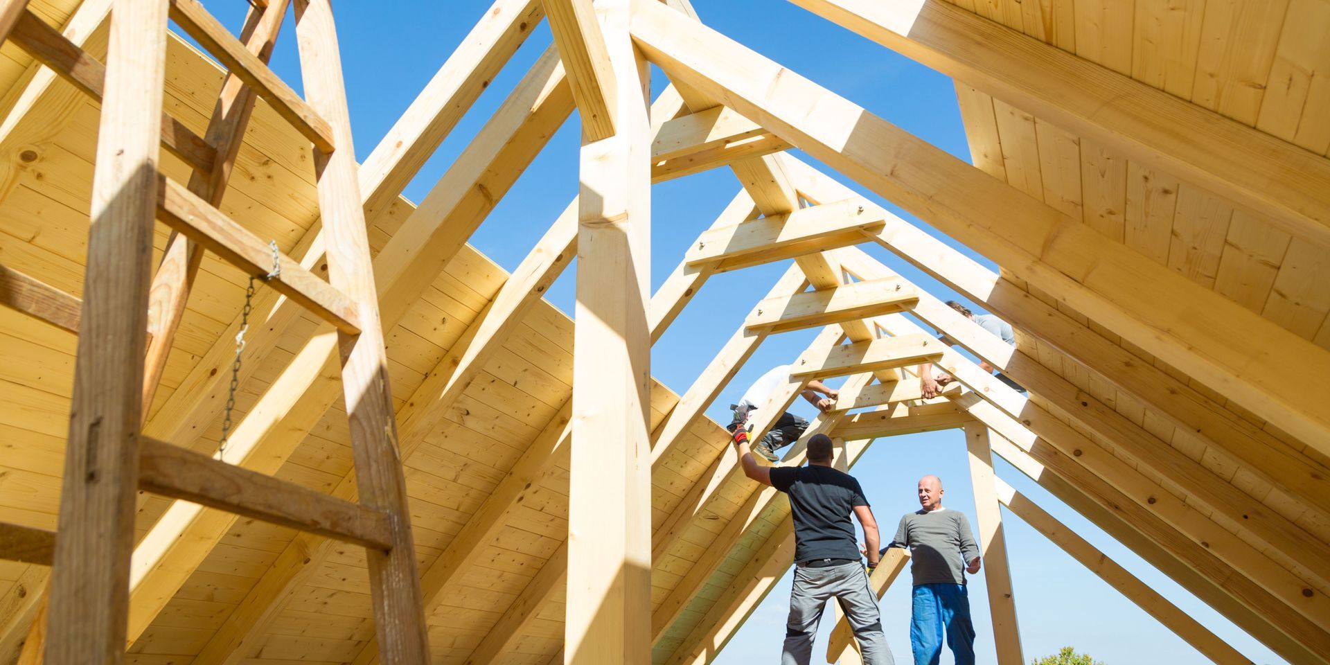 Two men are working on the roof of a house under construction.