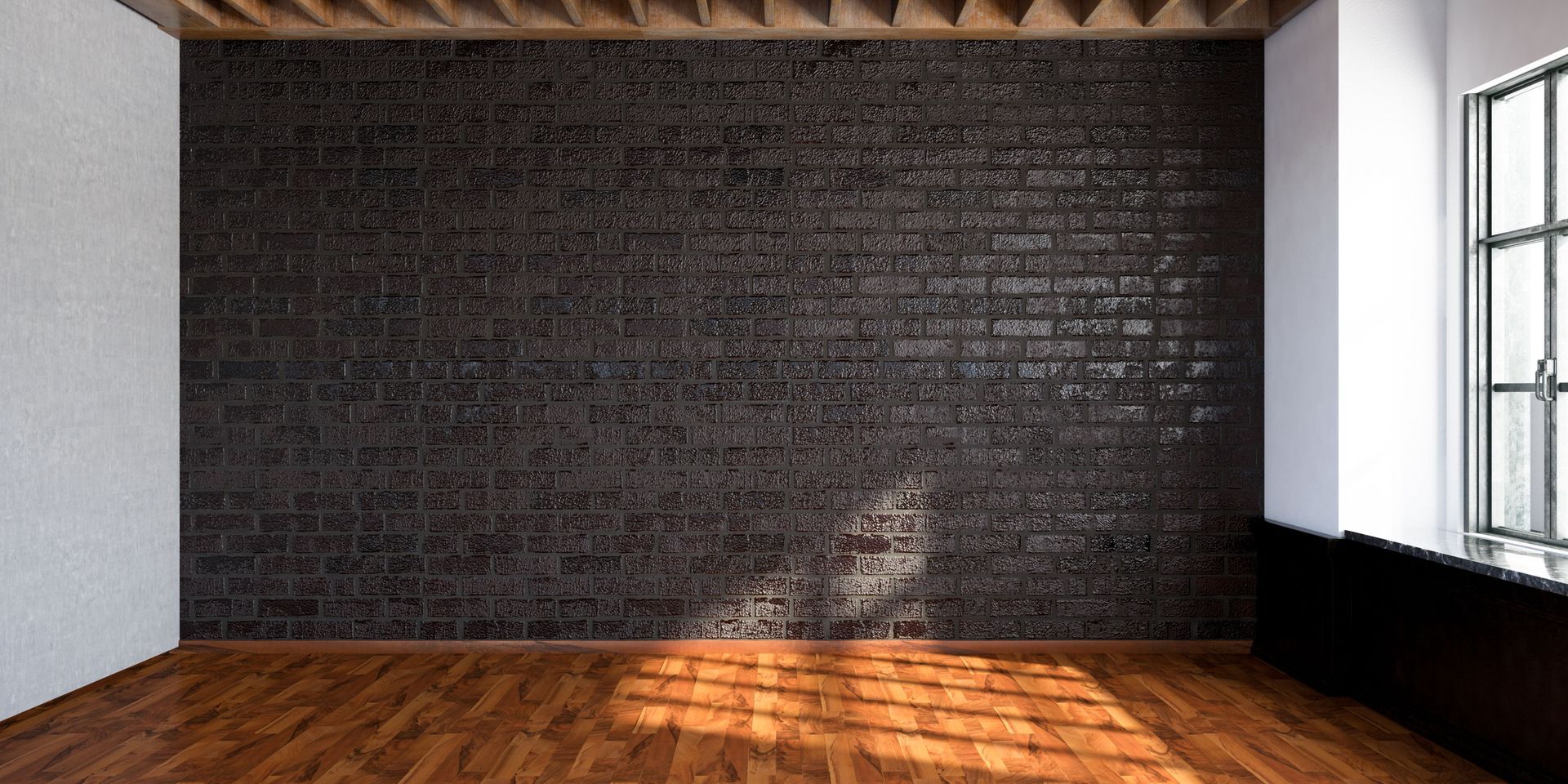 Empty room with dark brick wall, wooden floor, and window. Sunlight illuminates the floor.