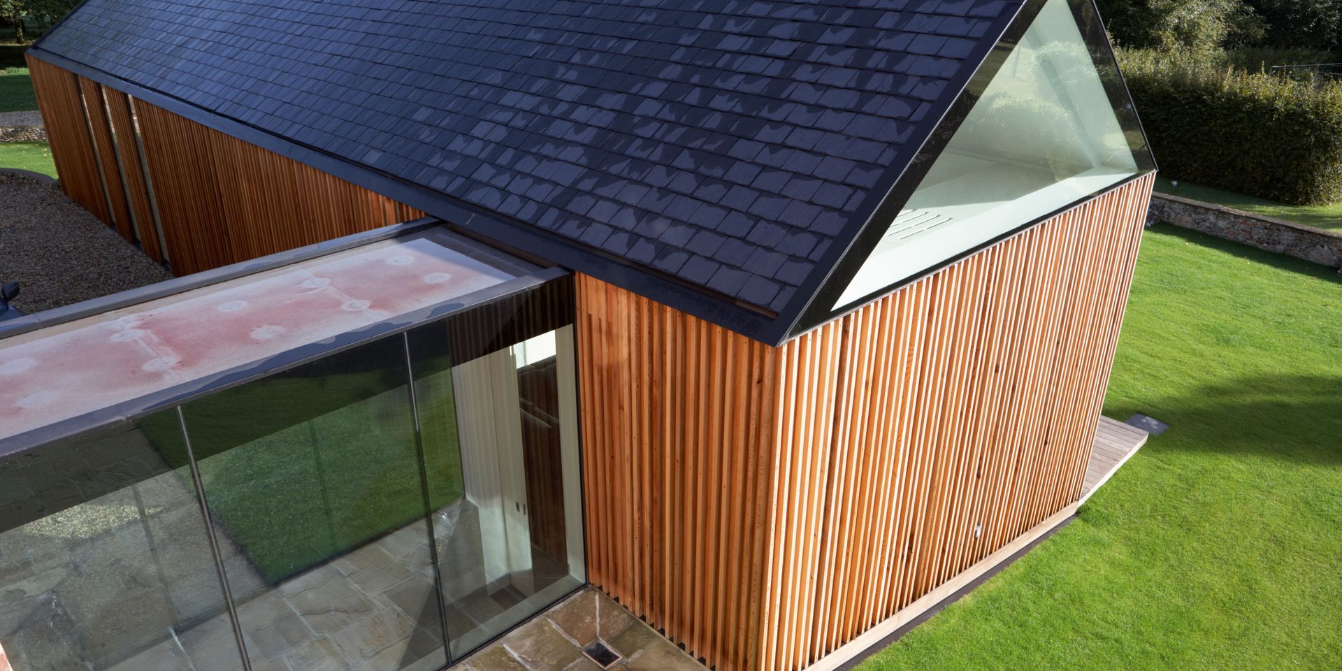 An aerial view of a house with a black roof and wooden siding.