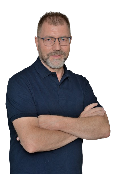 Ein Mann mit Brille und Bart steht mit verschränkten Armen