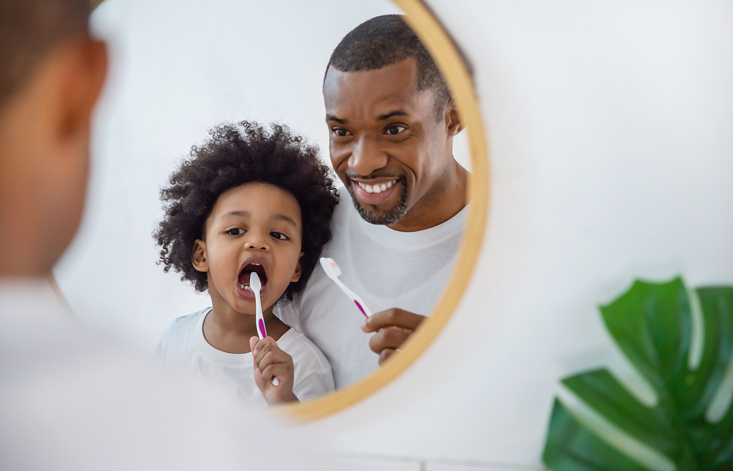 man and son brushing teeth
