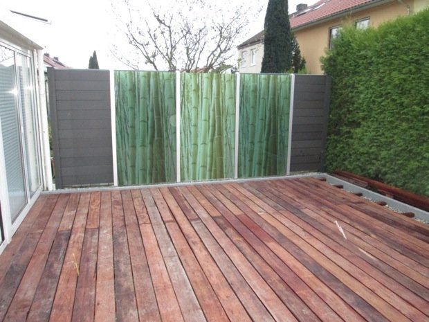 Ein Holzdeck mit einem Zaun im Hintergrund