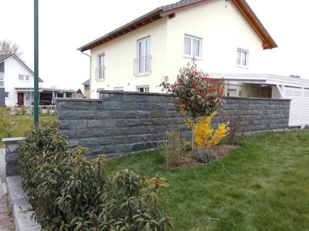 Ein Haus mit einer Steinmauer davor