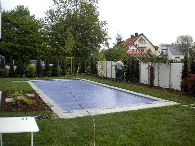 Ein Mann steht neben einem großen Swimmingpool