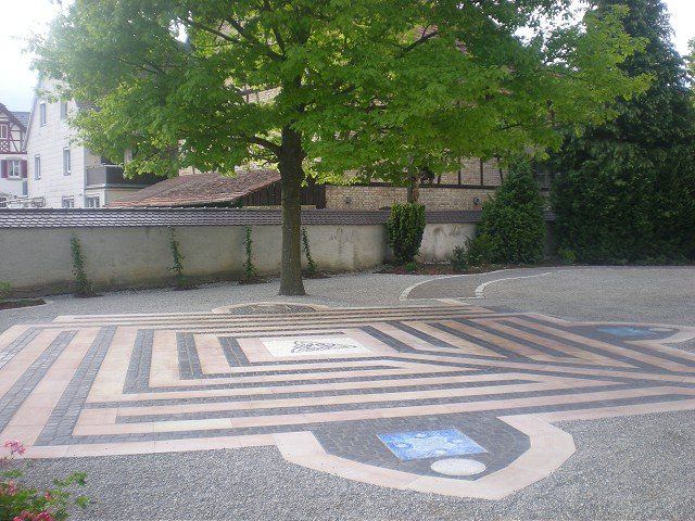 Ein Labyrinth auf einem Parkplatz mit einem Baum im Hintergrund