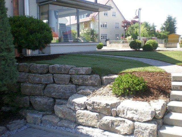 Eine Steinmauer und Treppen vor einem Haus