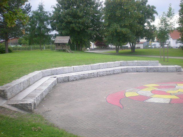Ein Park mit einer Bank und einem Spielplatz in der Mitte