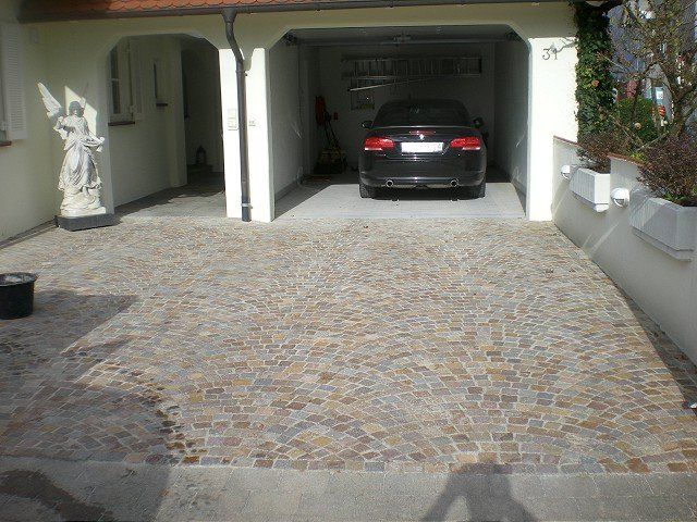 Ein Auto steht in einer Einfahrt neben einer Engelsstatue