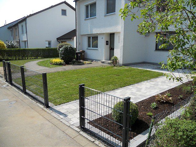 Ein weißes Haus mit einem Zaun davor