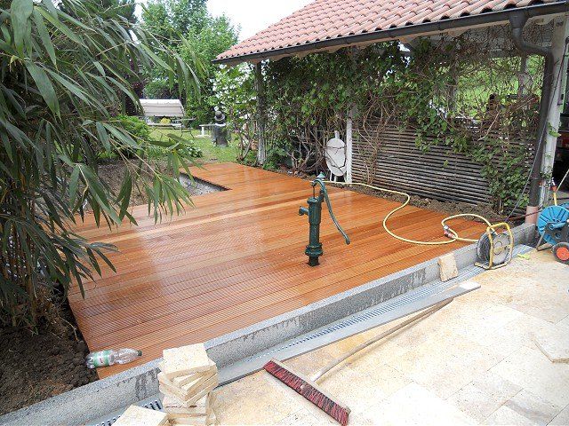 Vor einem Haus wird eine Holzterrasse gebaut.