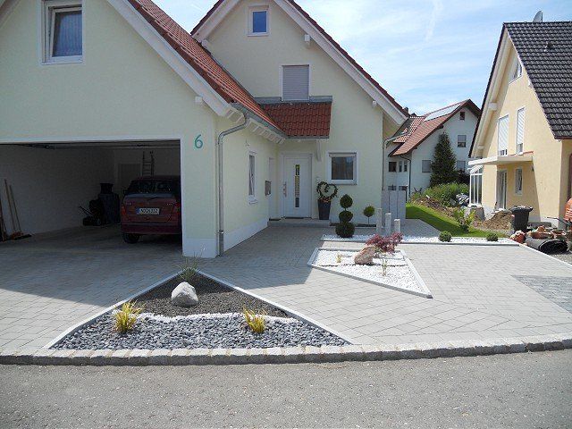 Ein weißes Haus mit einem davor geparkten roten Auto