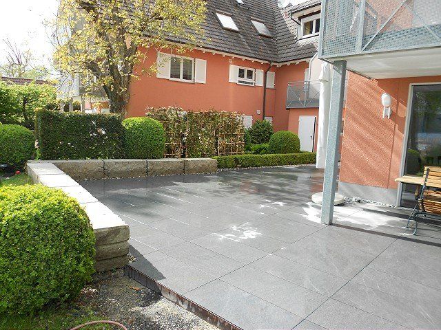 Eine Terrasse mit einer Bank vor einem Haus