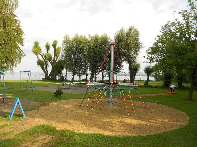 Ein Spielplatz in einem Park mit Bäumen im Hintergrund