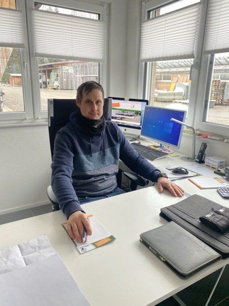 Ein Mann sitzt an einem Schreibtisch vor einem Computer