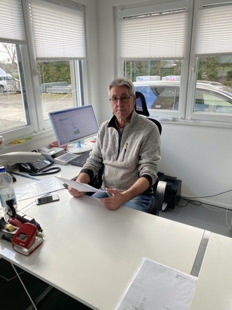 Ein Mann sitzt an einem Schreibtisch vor einem Computer.