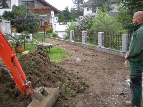 Ein Mann steht vor einem großen Erdhaufen.