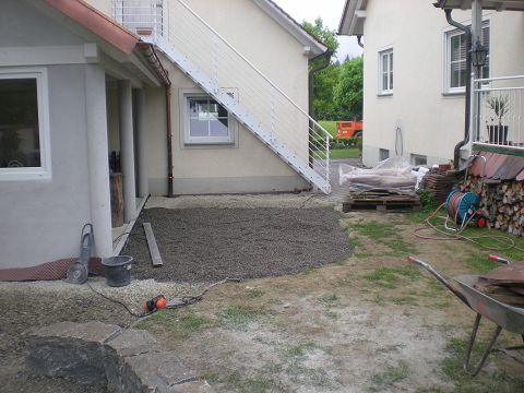 Ein Haus mit Treppe und einer Schubkarre davor
